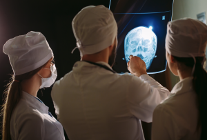 Doctors examining a patient’s x-ray of their head. TryMunity.